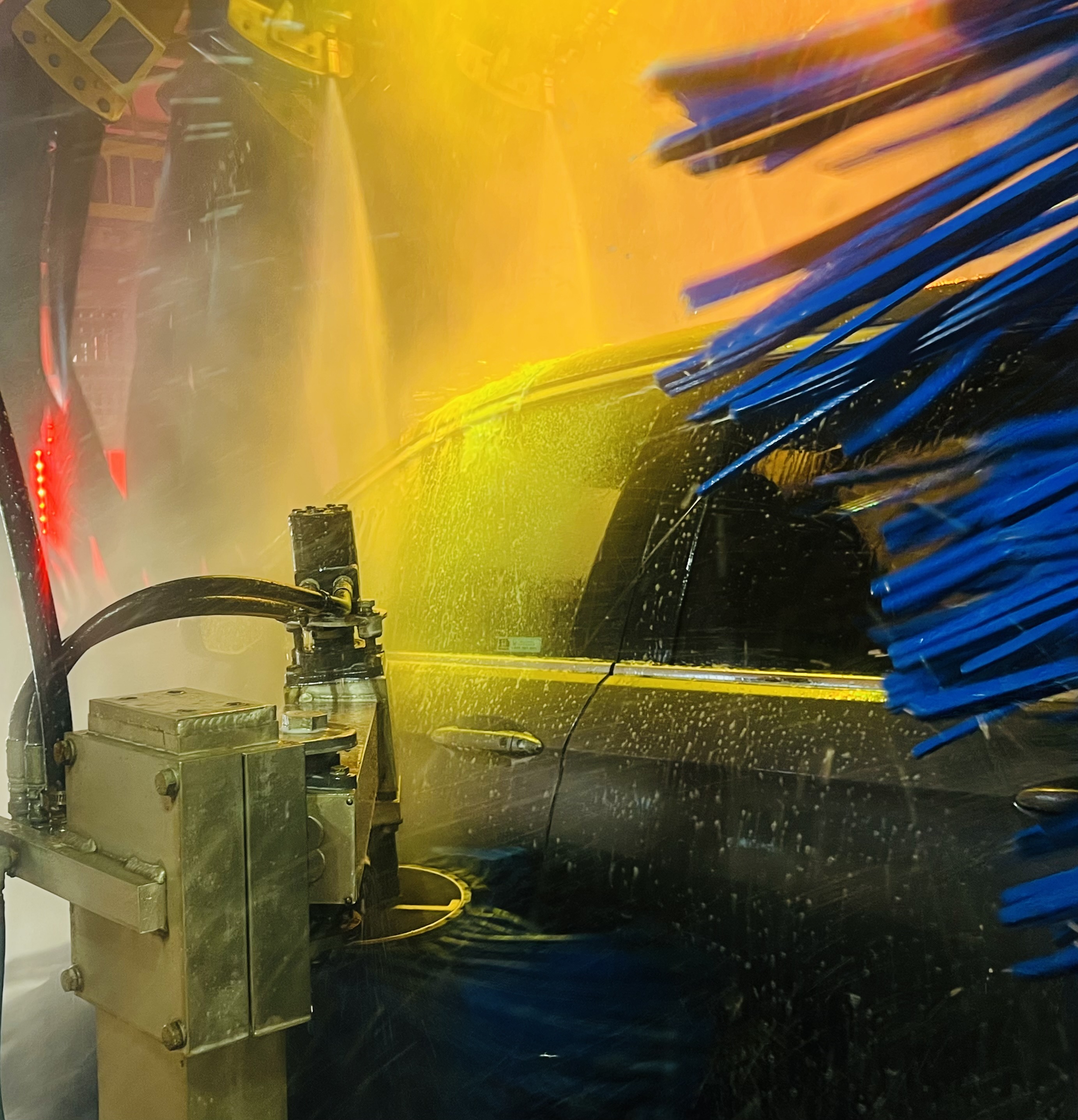 Soft-touch brushes washing a vehicle inside Brewer’s updated car wash tunnel